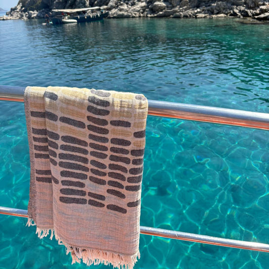 WAVES Turkish Towel with grey and beige pattern hanging on boat railing over turquoise Turkish Mediterranean sea