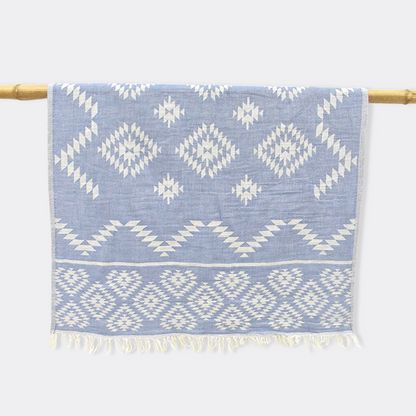 Light blue KILIM Double-Sided Turkish Hand Towel hanging from bamboo stick