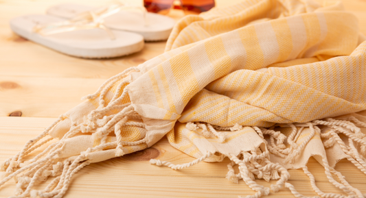 Striped classic Turkish towel in summer next to flip-flops and sunglasses