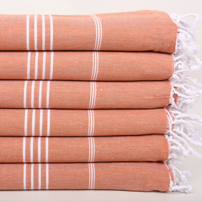 Stack of folded CLASSIC Turkish Towels in terracotta with white stripes & white hand-tied knots