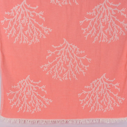 Coral-coloured Turkish towel with white coral patterns on a light gryy background