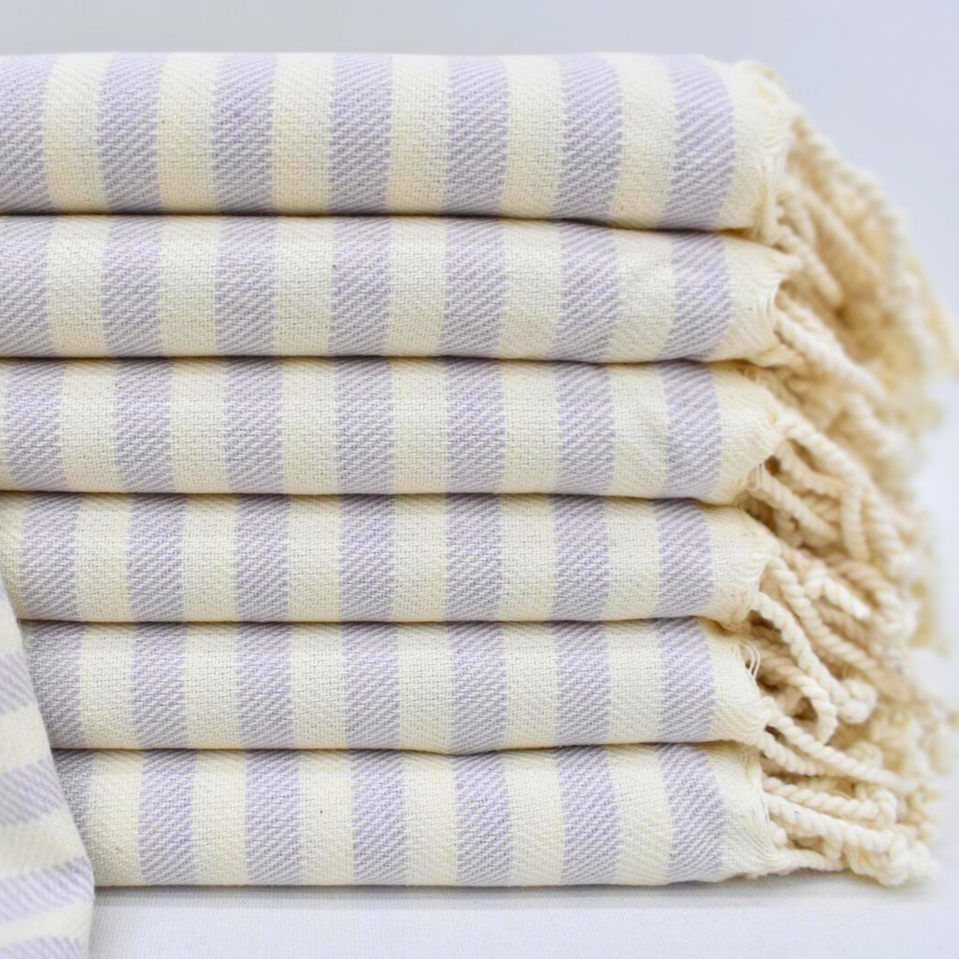 Stack of folded LAVENDER Turkish Towels with soft lavender colour stripes and natural colour hand-knotted fringes