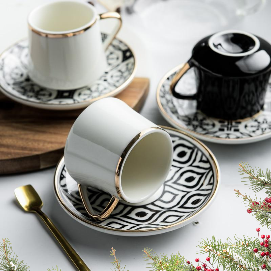 White and black patterned MODERN Turkish Coffee Cups and saucers on a decorative table with Christmas decorations.