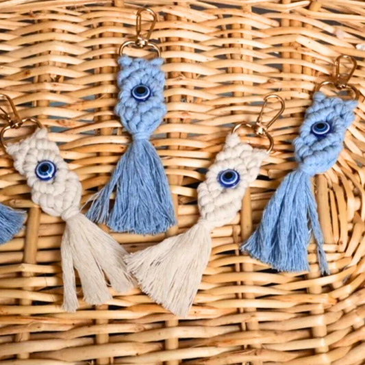 Macrome keychains with tassels and evil eye symbols on a woven surface
