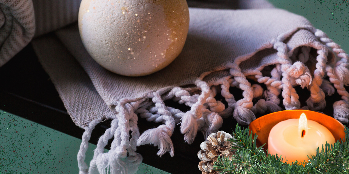 Turkish bath towel, bath bomb and candle on a bath tub with Christmas decor