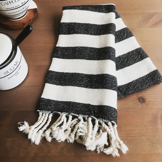 Folded striped BOLD MEDITERRANEAN Turkish Hand Towel with sugar canister and cappuccino on coffee table