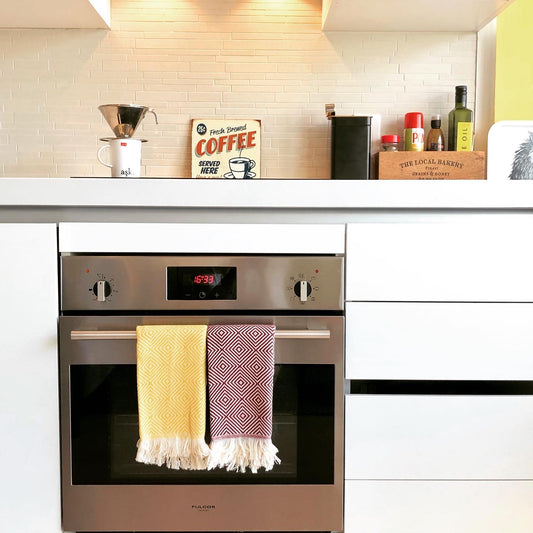 Burgundy and yellow PASHA Turkish hand towels used in bright kitchen