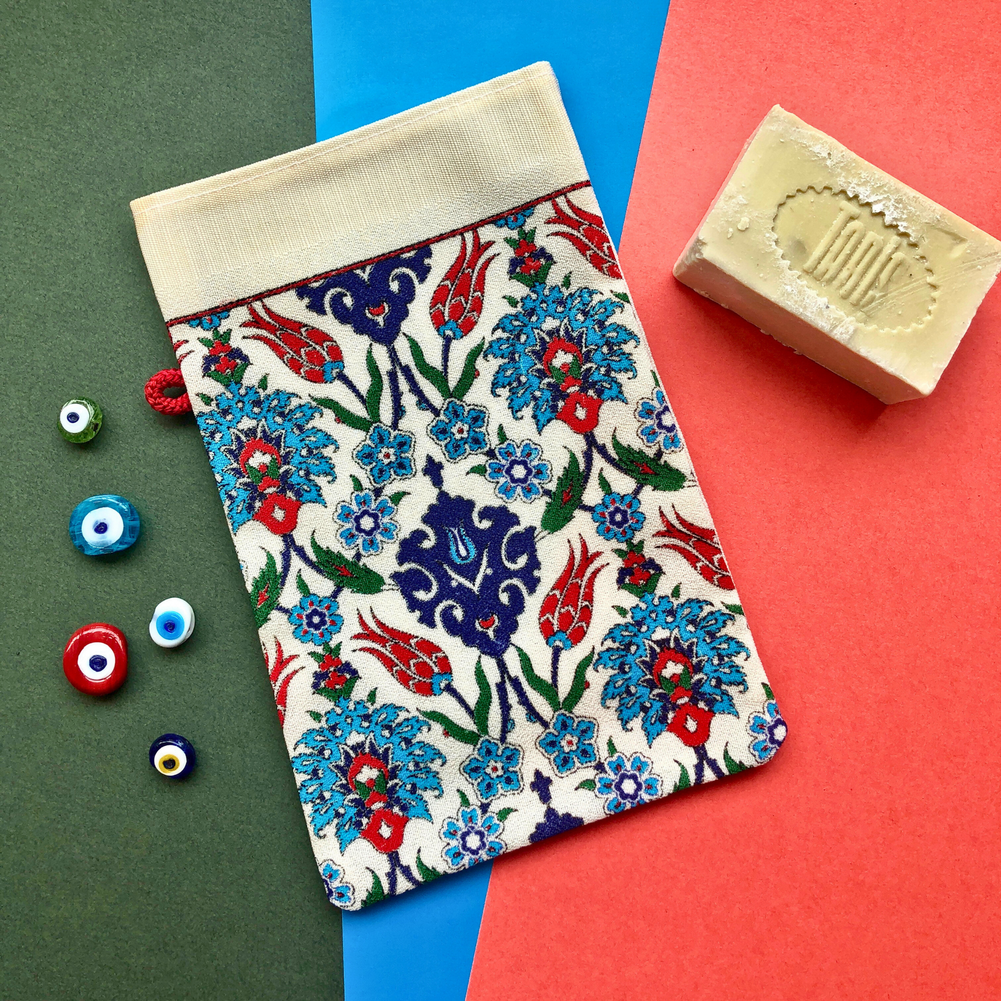 Turkish Bath glove exfoliator with colourful Turkish evil eye beads and olive oil soap on festive holiday background