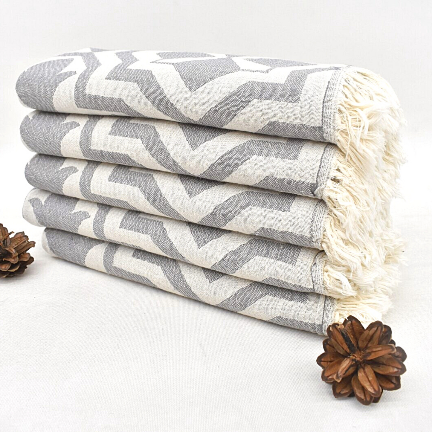 Stacked grey TULIP Turkish Kitchen Towels and pine cones