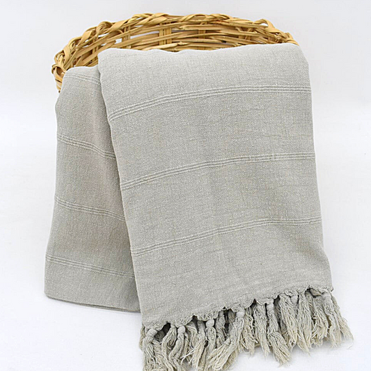 Grey ISTANBUL Stonewashed Blanket in a wicker basket