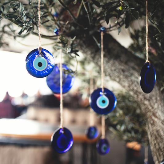 Blue evil eye amulets hanging on a tree