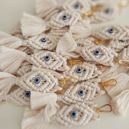 A pile of NAZAR Macrame Keychains with evil eye beads, golden colour snap hooks and natural colour cotton