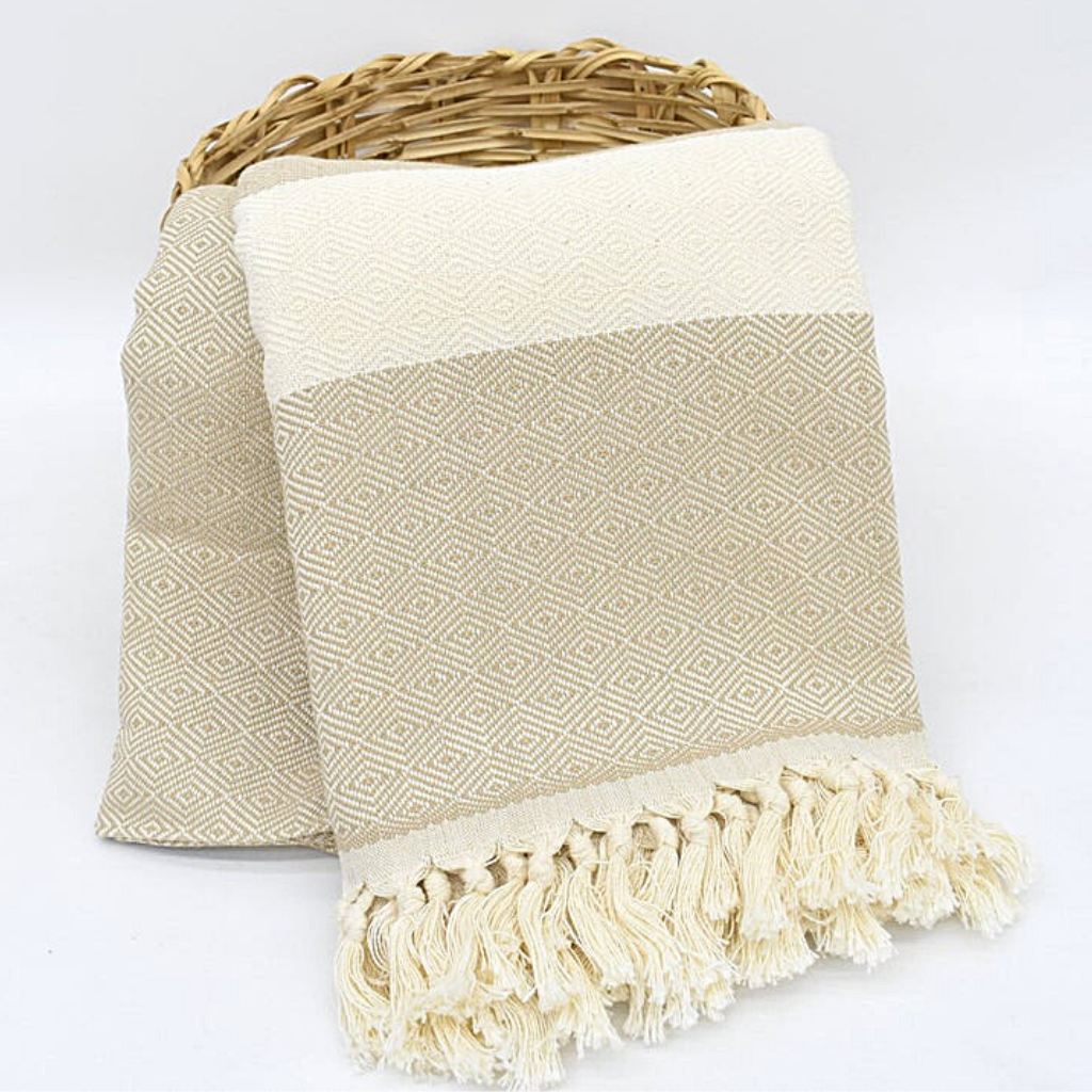 Beige SULTAN Blanket displayed in a wicker basket